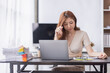 © David - Asian businesswoman are stressed while working on laptop, Tired asian businesswoman with headache at office, feeling sick at work copy space in workplace an home office.