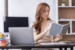 © David - Asian Businesswoman holding notes and working on a laptop computer in the workplace, doing document planning analyzing the financial report, business plan investment, finance analysis concept.