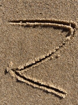 On the beach in the sand is carved the letter Z