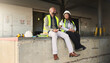 © Nicholas Felix/peopleimages.com - Business people, logistics, and lunch break at work site relaxing, talking and enjoying free time on the job. Black man and woman employee in shipping yard, warehouse or factory industry at rest