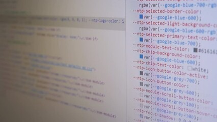 Programmer Views the HTML Code of the Page on a Screen of a Computer Monitor. Code scrolling. Study, analysis of a web page, site. Signs, symbols, numbers, words. Software. White abstract background.