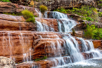 Wall Mural - Water blur on beautiful and small waterfall among the rocks and vegetation of the Biribiri environmental reserve in Diamantina, Minas Gerais.