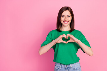 Wall Mural - Portrait of young funny smiling attractive girl showing heart lovely have feelings isolated on pink color background