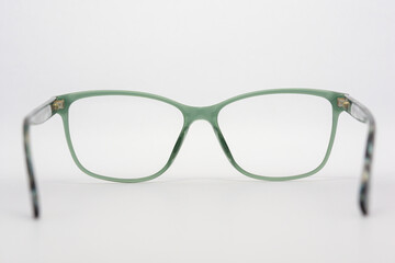 Eyeglass frames, lenses, various colors, both metal and plastic, on a beautiful colored background.