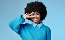 Young, Black Woman And Shows Peace Sign With Blue Studio Background, Trendy Style And Afro. Smile, Happy And Relax African American Female, Lady Or Girl Influencer With Casual Fashion And Cosmetics.