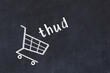 Chalk drawing of shopping cart and word thud on black chalboard. Concept of globalization and mass consuming