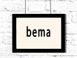 Black frame hanging on white brick wall with inscription bema