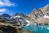 Fototapeta Góry - View of a blue mountain lake in the Caucasus Russia against the background of impressive steep mountain peaks