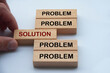 Hand putting wooden block with word solution in the middle of wooden blocks with words problem. Solution concept