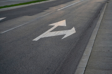 a close-up of a sign drawn on the road signifying a right turn or straight ahead. Tools for regulating traffic rules. Road signs.