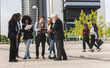 © PintoArt - Large group of business people walking in front of office buildings. multiracial people say goodbye as they leave work.