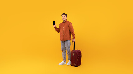 Leinwandbilder - Cheerful Male Tourist Showing Smartphone Empty Screen Over Yellow Background
