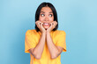 Photo of horrified scared cute woman with bob hairstyle wear yellow t-shirt look empty space bite hands isolated on blue color background