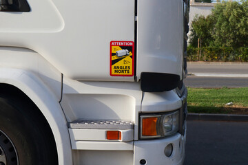 Sticker in a professional truck cabin indicating the existence of a blind spot in that area