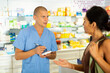 © JackF - Buyer dictates the medicine to the pharmacist to write in a notebook