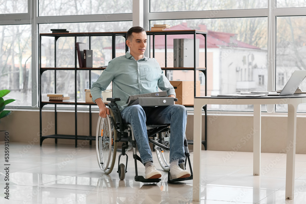 Young man with physical disability working in office