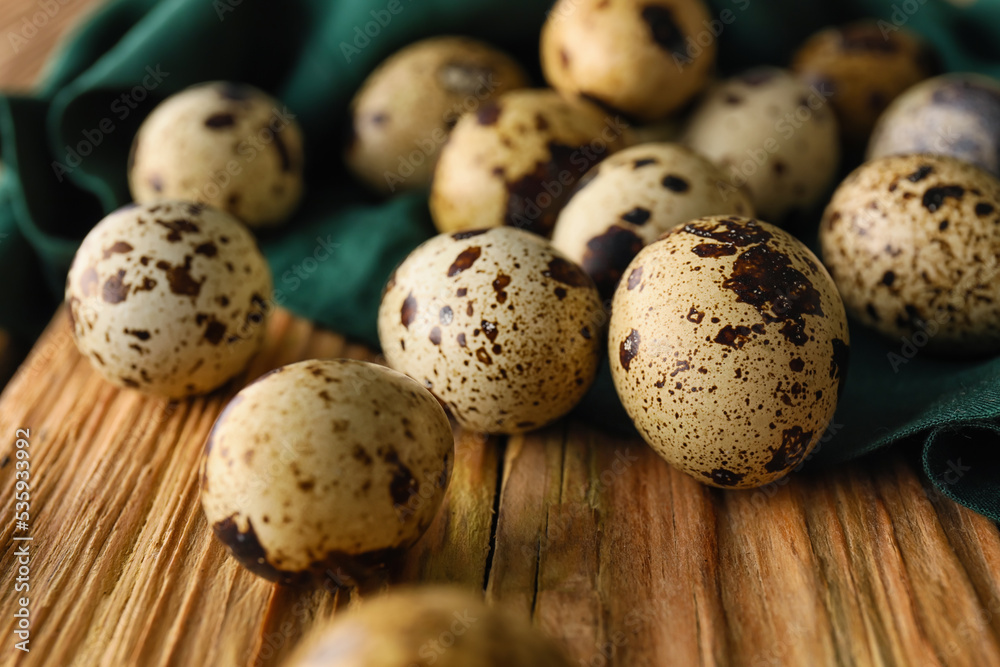Fresh quail eggs on wooden background, closeup
