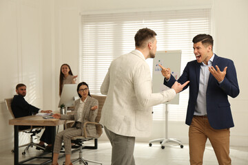 Wall Mural - Emotional colleagues fighting in office. Workplace conflict