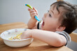 © Klarion - toddler eating eggs for breakfast and fooling around