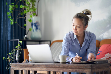 Wall Mural - mature asian woman working from home using notebook computer