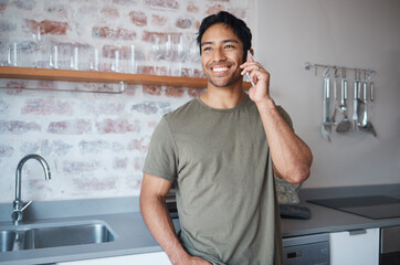 Fototapete - Happy, smile and man on a phone call in the kitchen of his home talking on technology for communication. Happiness, young and man from colombia having mobile conversation on a smartphone in his house