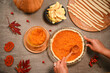 © Taras Grebinets - Top view houswife making homemade American classic pie for Thanksgiving Day. Red autumn maple leaves, viburnum berries, mashed pumpkin, apple slices and strips for making flaky crust on kitchen table
