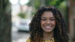 © Marco - One happy black girl smiling. Portrait of a joyful African American young woman with curly hair. Female person with authentic real life laugh and smile