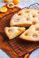 Poster - Delicious homemade apricot pie with fresh apricots on baking grid on gray background with napkin. Summer fruit pie.