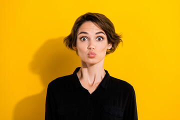 Photo of impressed millennial short hair lady blow kiss wear black shirt isolated on yellow color background