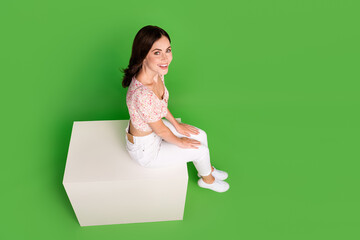 Canvas Print - Full length high angle view photo of sweet shiny girl dressed print blouse sitting white platform empty space isolated green color background