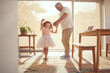 © David L/peopleimages.com - Family, young girl and grandfather dancing in living room together. Grandparent and grandchild in family home doing dance and having fun in the morning. Old man enjoying retirement with child at home