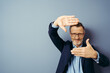 © contrastwerkstatt - handsome business man over blue isolated background smiling making frame with hands and fingers with happy face. Creativity and photography concept.