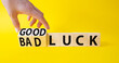 Good Luck and bad Luck symbol. Hand turns a cube and changes the words Bad Luck to Good Luck. Beautiful yellow background. Businessman hand. Business concept. Copy space