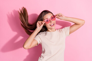 Canvas Print - Photo of pretty satisfied lady arms touch sunglass toothy smile flying hair isolated on pink color background