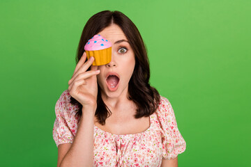 Poster - Photo of adorable impressed gorgeous girl with wavy hairstyle wear blouse cake cover eye staring isolated on green color background