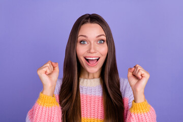 Wall Mural - Photo of astonished pretty girlish woman long hairdo hold fist up near face open mouth shouting yeah isolated on violet color background