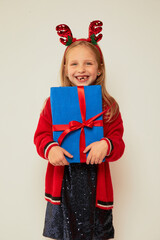 Wall Mural - Smiling funny child (kid, girl)  holding Christmas gift box