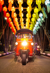 Tuktuk crossing a bridgeduring Loy Krathong Festival in Chiang Mai Thailand