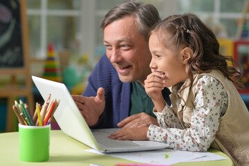 Poster - Portrait of father with daughter use laptop