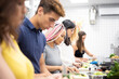 © ADDICTIVE STOCK - Multiracial people learning how to cut vegetables at cooking workshop