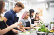 © ADDICTIVE STOCK - Multiracial people learning how to cut vegetables at cooking workshop