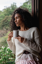 Dreamy Black Woman With Cup Of Coffee Admiring Nature Outdoors