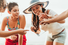Cheerful Girlfriends With Crab On Seashore