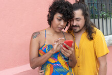 Ethnic Couple Browsing Smartphone Together In City