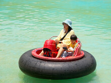 Mother And Son Having A Fun In Water Park With Bumper Boat