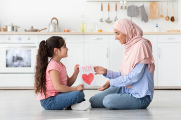 Wall Mural - Surprise For Mom. Girl Giving Greeting Card To Muslim Mommy At Home