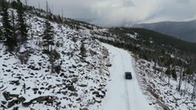 Flying A Drone Behind A Car In The Winter Mountains. Jeep Grand Cherokee Wk2 On Snow In The Forest
