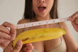 Sexy woman smiling with sweet banana and measurement tape.