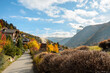 The path leads to the beginning of the mountain village, in front of which there is a magnificent view of the mountains and rocks with autumn trees