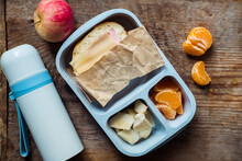 Schoolboy Lunch Box With Thermos On Wooden Background.apple,tangerine,sandwich In Lunchbox And Water Bottle
